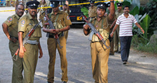 Sri Lankan police officers gather following a shootout on the outskirts of Colombo, Sri Lanka, Saturday, Oct. 8, 2011. A police official said former lawmaker Bharatha Lakshman Premachandra and two of his supporters were killed Saturday in an intraparty shootout during local council elections. (AP Photo/ Eranga Jayawardena)